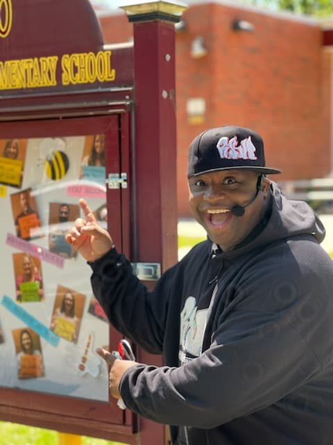 David Jack performing at a school assembly with students